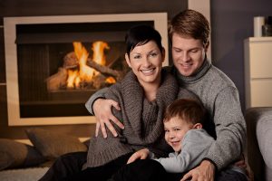 Photo of a happy family with a working furnace and fireplace