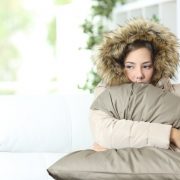 Cold person with cold air blowing out of the furnace
